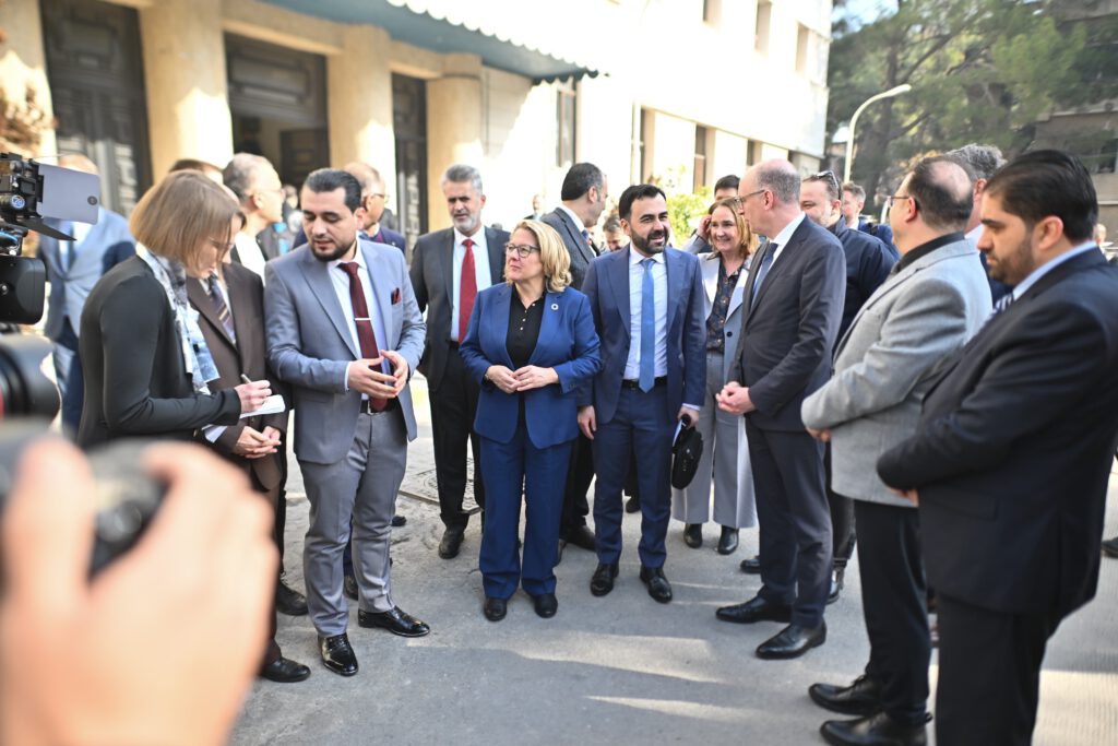 Entwicklungsministerin Svenja Schulze und Dr. Iyad Durmus stehen in mitten der Delegatopm