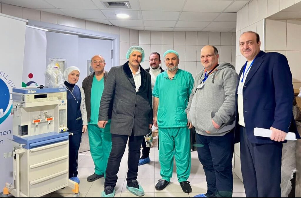 Medizinisches Fachpersonal des Universitätsklinikums in Aleppo und Begleitpersonen posieren für ein Gruppenbild neben einem der neuen Anästhesiegeräte.